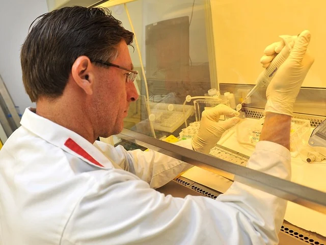 Szakember pipettával mintát adagol a laboratóriumi edénybe
